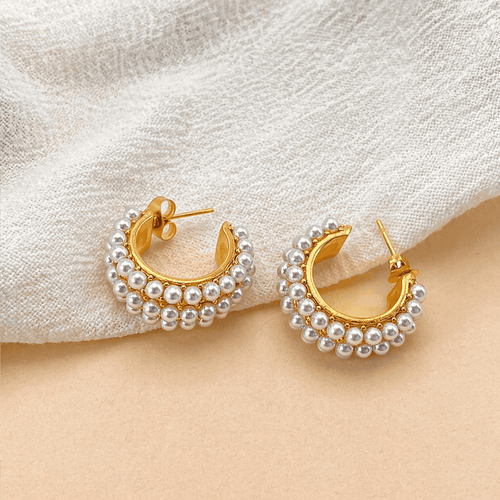 Eleganckie i ponadczasowe, Elysian Pearls i Złote Kolczyki to delikatne złote kolczyki z perłami, które dodają luksusu i elegancji każdemu strojowi. Idealne dla kobiet ceniących wysokiej jakości biżuterię o minimalistycznym designie.

